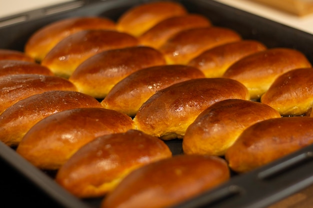 Sweet hot buns on a baking sheet Yeast dough Bakery in the kitchen Homemade baking