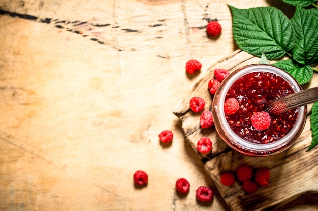 Sweet jam with raspberries. On a wooden table.