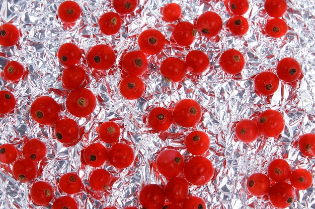 Sweet juicy red currant on a foil background View from above Vegetarian food concept