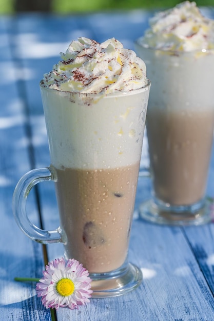 Sweet latte with cream in sunny day