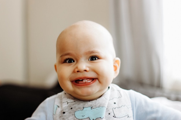 Sweet little baby boy with chubby cheeks and big eyes. Portrait of happy smiling infant