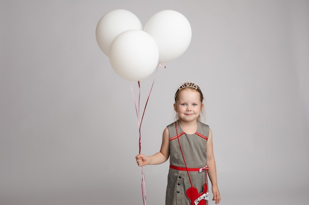 Sweet little girl with air balloons in studio.