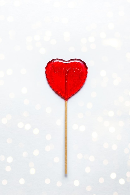 Sweet lollipop on white background with bokeh. Red heart. Candy. Love concept. Valentine day