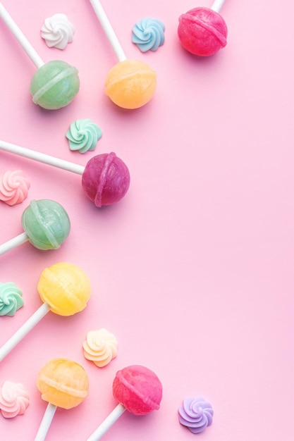 Photo sweet lollipops and candies on pink background