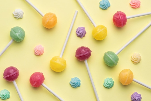 Sweet lollipops and candies on yellow background