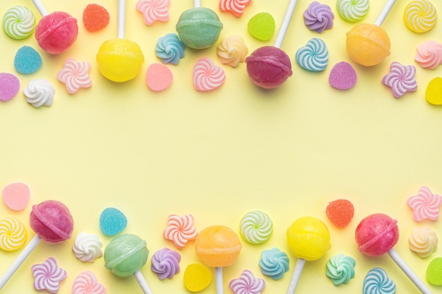 Lecca-lecca dolci e caramelle su sfondo giallo