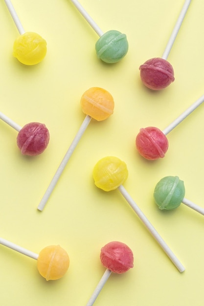 Sweet lollipops on yellow background