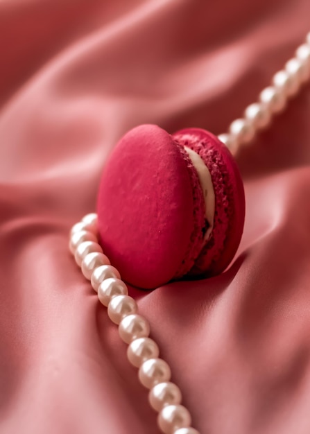 Amaretti dolci e gioielli di perle su sfondo di seta gioielli chic parigino cibo da dessert francese e macaron per torte per regalo di festa di marca di dolciumi di lusso