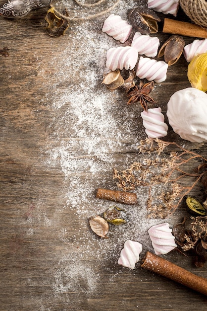 Sweet marshmallow pieces with different ingredients on wooden background. Top view. Copy space