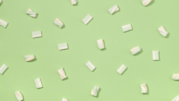 Фото Сладкий зефир в минимализме на пастельном яблочно-зеленом фоне
