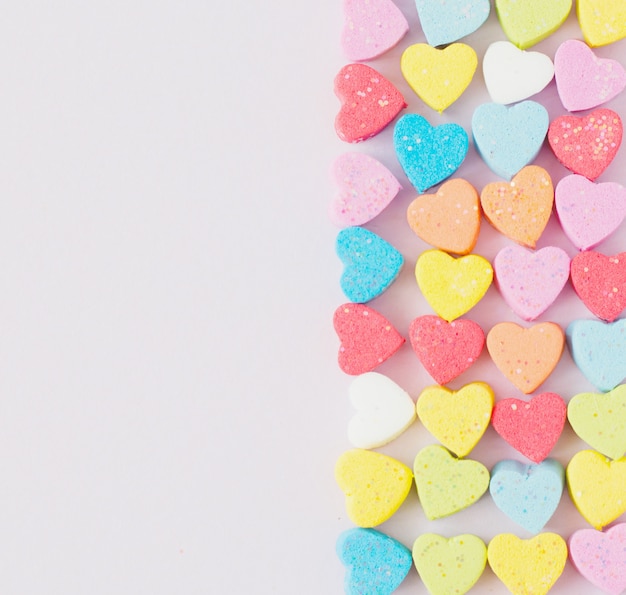 Sweet mini hearts in colorful on pastel background 