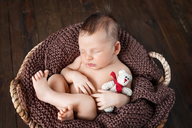 Sweet newborn baby sleeps with a toy.