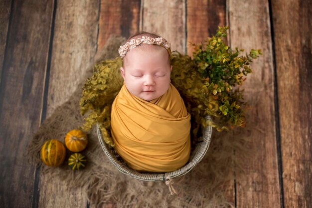 Sweet newborn girl in romper sleeping on round cot