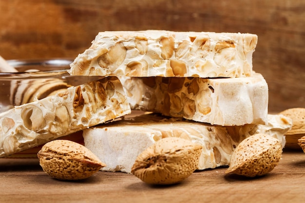 Sweet nougat in pieces on a wooden background in a close up view