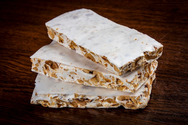 Sweet nougat with nuts on dark background