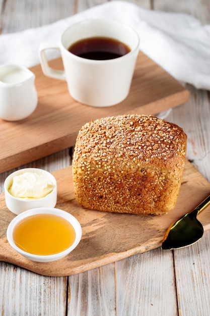 Sweet oats and wheat bread with honey and butter on the wooden board