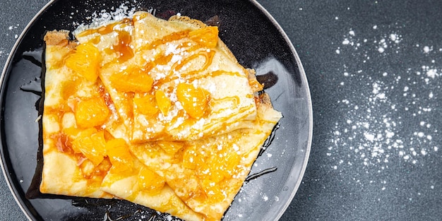 Sweet pancake crepe orange syrup fresh eating cooking appetizer meal food snack on the table