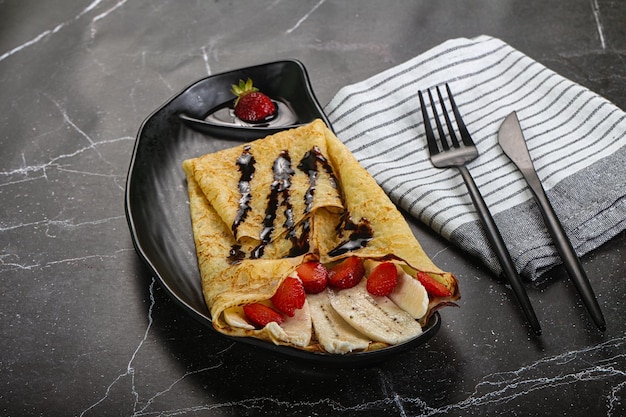 Photo sweet pancake with banana and strawbeery