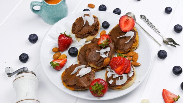 Sweet pancakes chocolate strawberry top view white background