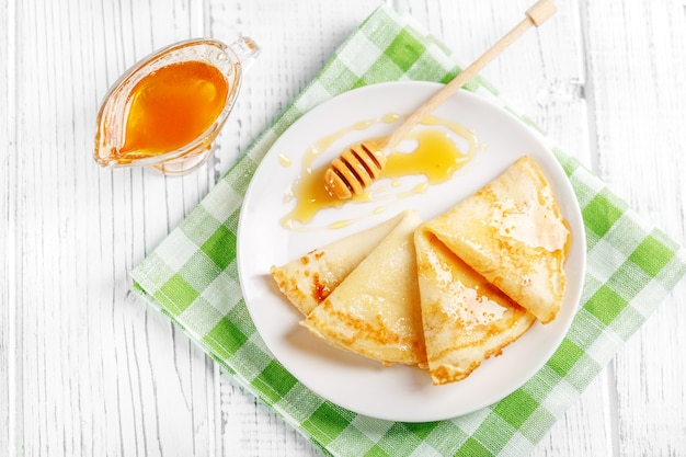 Sweet pancakes with honey on a plate. 