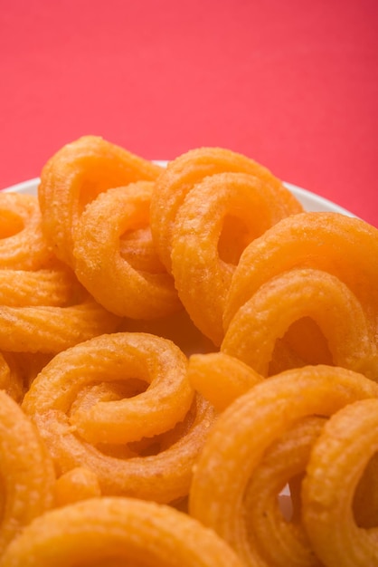 Photo sweet paneer jalebi served in a ceramic plate over colourful or wooden background. selective focus