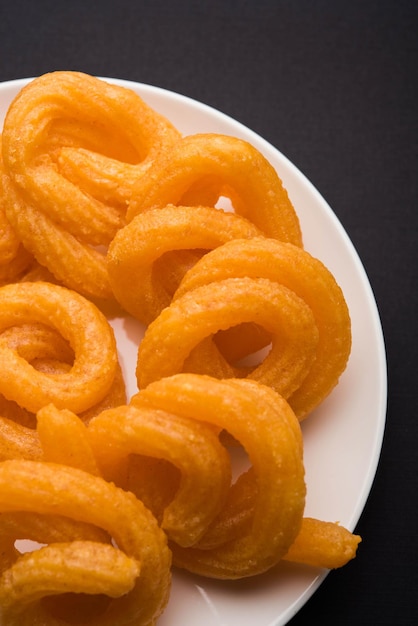 Sweet paneer jalebi served in a ceramic plate over colourful or wooden background. selective focus