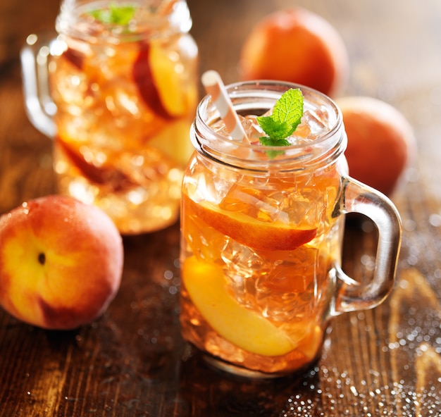 Sweet peach tea in a jar on wooden table