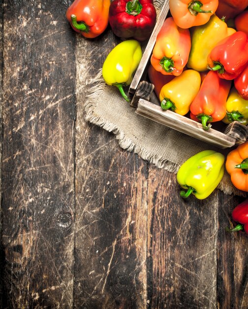 Sweet pepper in an old box. On a wooden background.