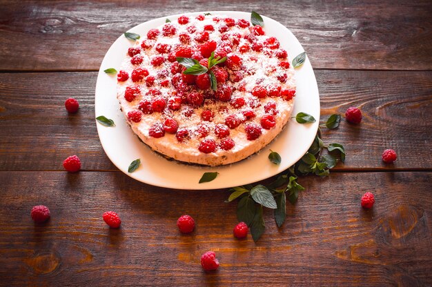 Sweet pie with raspberry on wooden table