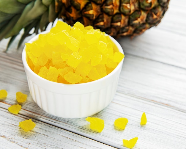 Sweet pineapple cubes on white wooden background