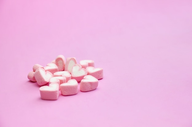 Photo sweet pink marshmallows on pink background with copy space