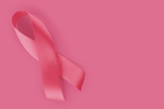 Sweet pink ribbon shape on pink background paper for breast cancer awareness symbol to promote in the month of October campaign