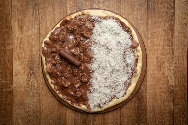 Foto pizza dolce con cioccolato e cocco grattugiato. vista dall'alto.