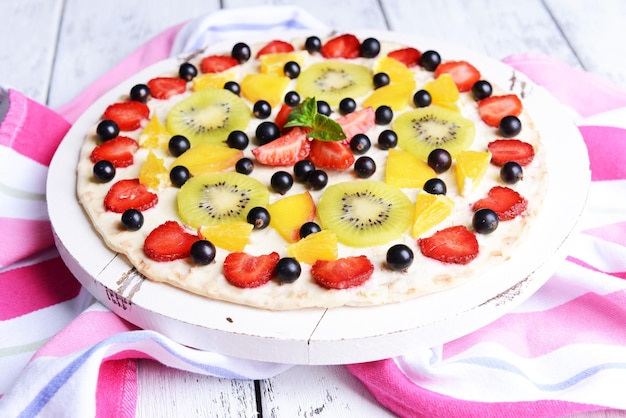 Photo sweet pizza with fruits on table closeup