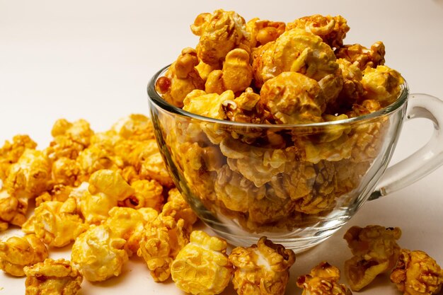 Photo sweet popcorn in a glass cup on a white background