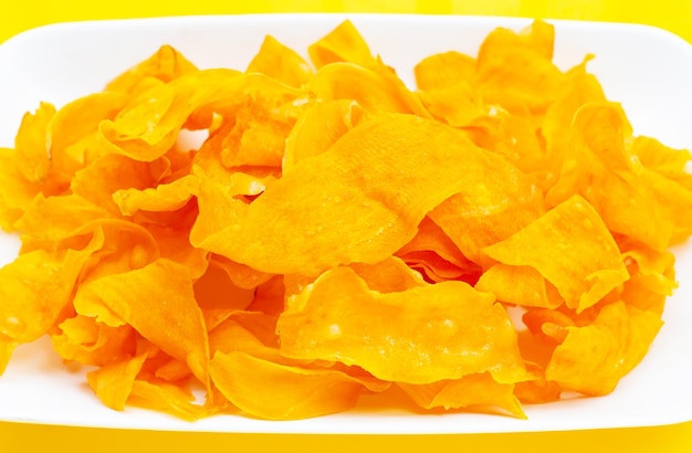 Sweet potato chips on yellow background