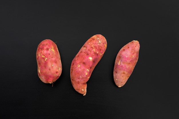 Sweet potato on dark background. Top view