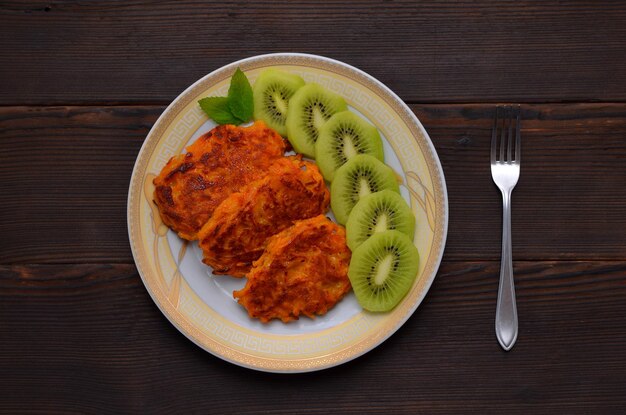 Sweet potato pancakes and kiwi slices on a plate flat lay