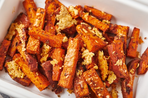 Sweet potato with cheese backed in bowl on grey background