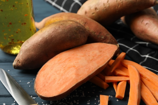 Sweet potatoes and ingredients on wooden surface