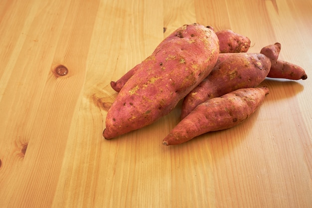 Sweet potatoes on a rustic wooden table