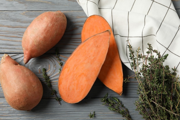 Sweet potatoes and thyme on wooden surface