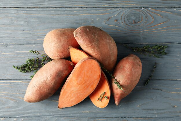 Sweet potatoes and thyme on wooden surface