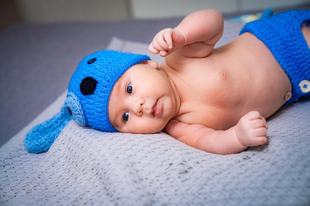 Sweet pretty child lying on the blanket Small cute newborn baby in funny hat