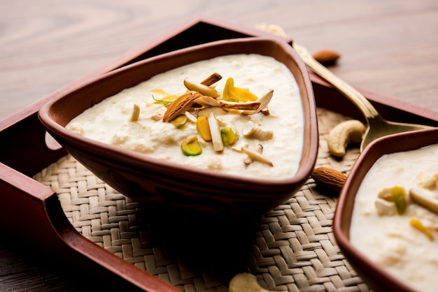 Sweet Rabdi or Lachha Rabri or basundi, made with pure milk garnished with dry fruits. Served in a bowl over moody background. Selective focus