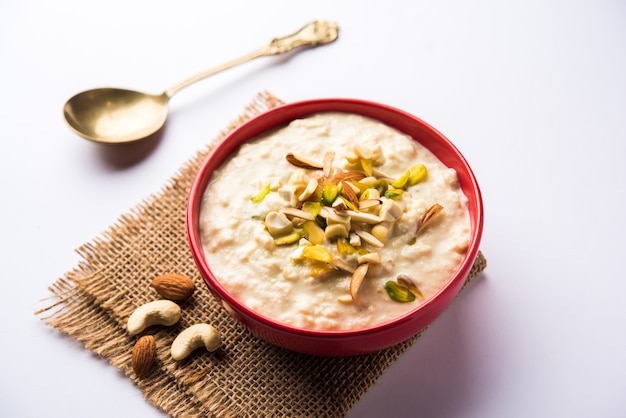 Sweet Rabdi or Lachha Rabri or basundi, made with pure milk garnished with dry fruits. Served in a bowl over moody background. Selective focus