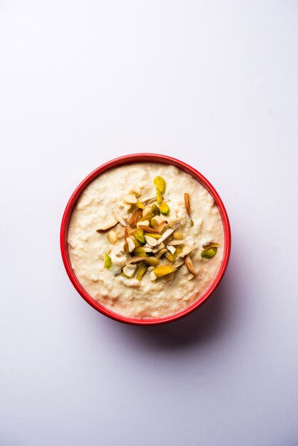 Sweet Rabdi or Lachha Rabri or basundi, made with pure milk garnished with dry fruits. Served in a bowl over moody background. Selective focus