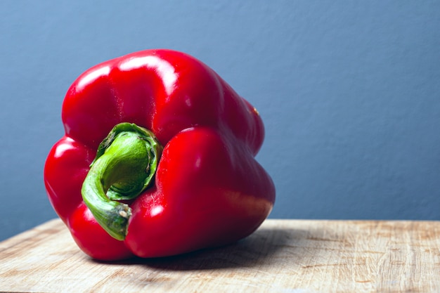 Sweet red big paprika pepper on a gray background with copy space close-up.