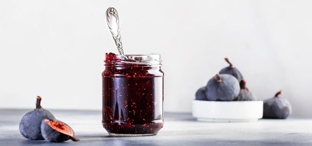 Sweet Red Fig Jam Jar Fresh blue figs Homemade preparations and canning Gray table background copy space