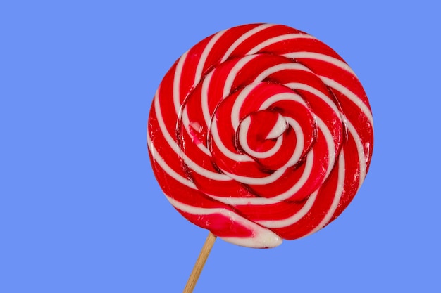 Sweet red lollipop on blue background